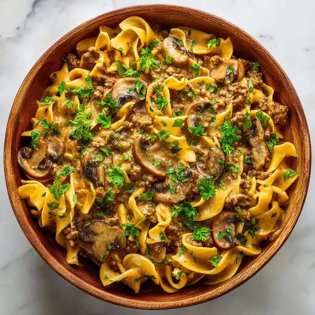 Ground Beef Stroganoff (The Ultimate 30-Minute Recipe) 2 A close-up shot of the rich and savory sauce for hamburger stroganoff simmering in a skillet with mushrooms and ground beef.