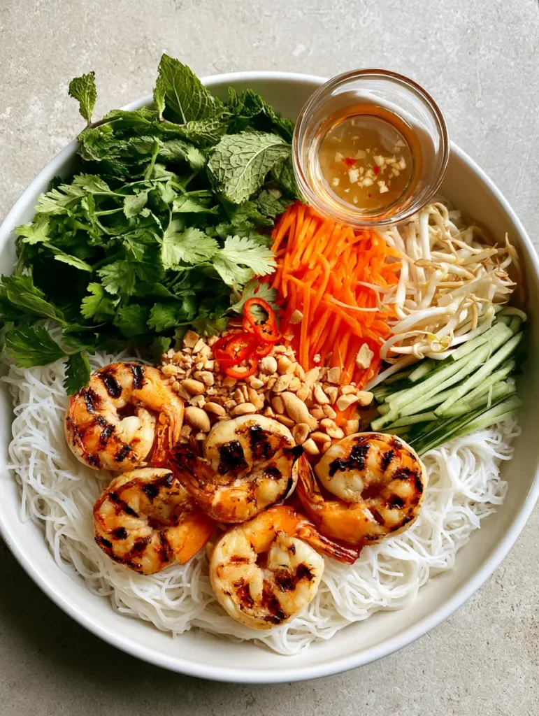 Vietnamese Noodle Salad with Smoky Charred Shrimp and Tangy Nuoc Cham 1 Close-up of Vietnamese Noodle Salad showing the texture of charred shrimp and the clear amber nuoc cham sauce with minced garlic.