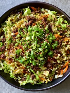 Close-up of glistening Ginger Ground Beef Stir Fry with translucent dark amber sauce and orange carrot matchsticks.