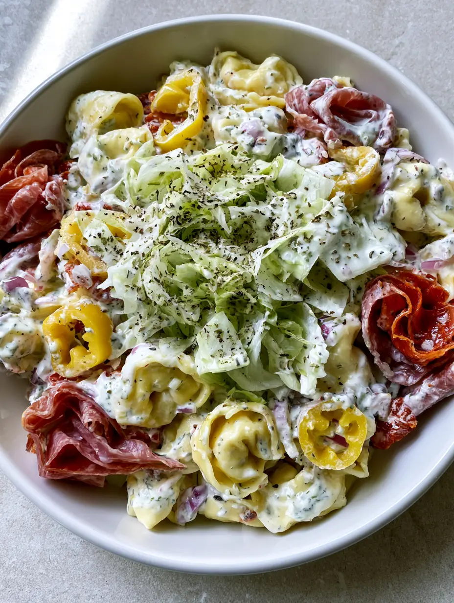 Italian Grinder Tortellini Salad: The Ultimate Viral Creamy Pasta Mashup 3 High-angle close-up of Italian Grinder Tortellini Salad showing the thick herb-flecked creamy dressing and cracked black pepper.