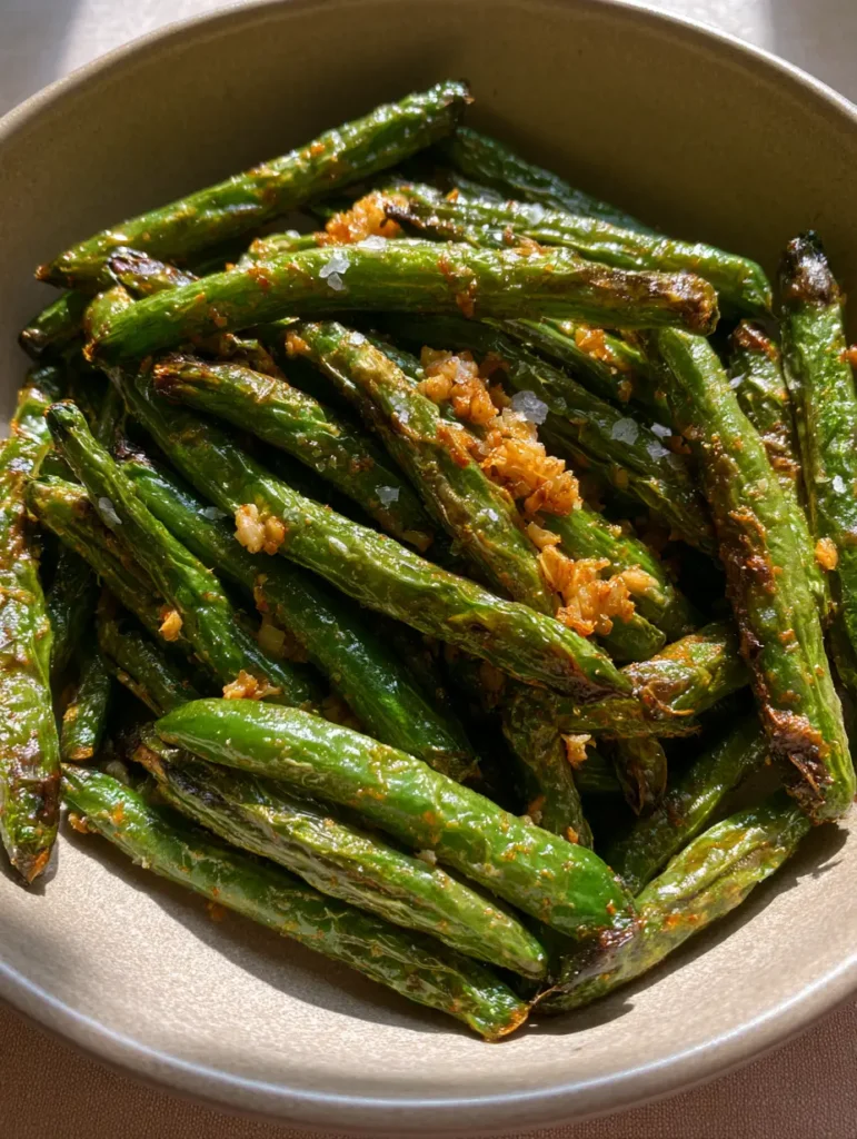 Mound of air-fried green beans tossed with minced sauteed garlic and black pepper.