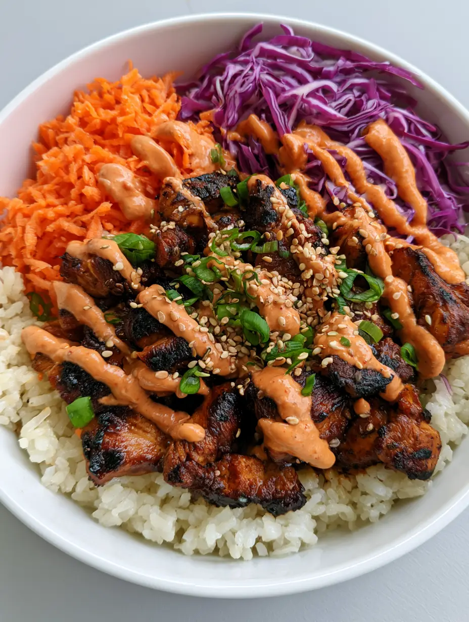 Korean BBQ Chicken Bowls with Creamy Gochujang Drizzle 4 Top-down smartphone photo of a Korean BBQ Chicken Bowl with vibrant purple cabbage and a salmon-colored sauce zigzag. (Korean BBQ Chicken Bowls)
