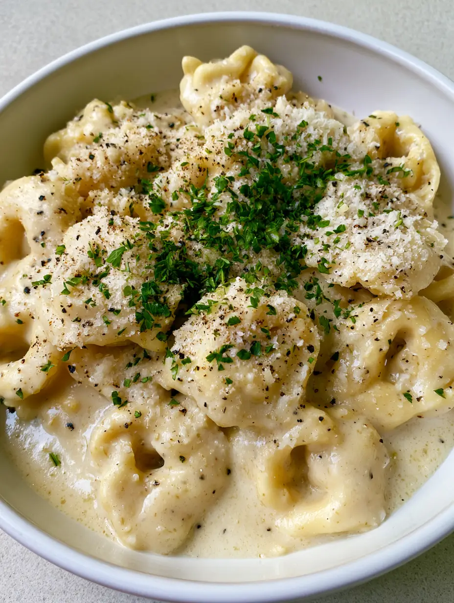 Creamy Garlic Butter Tortellini: The Ultimate 20-Minute Comfort Meal 3 Smartphone photo of Creamy Garlic Butter Tortellini in a shallow white bowl with glossy sauce and cracked black pepper.
