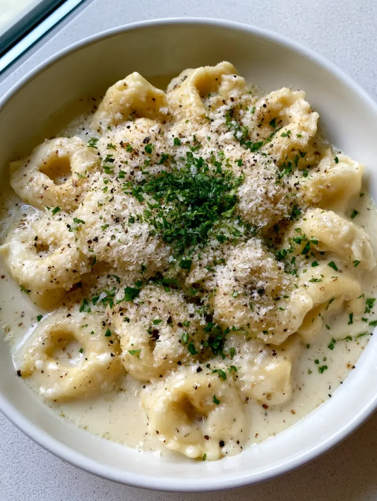 Creamy Garlic Butter Tortellini: The Ultimate 20-Minute Comfort Meal 1 Close-up of plump cheese tortellini coated in a thick, pale-ivory garlic butter cream sauce.